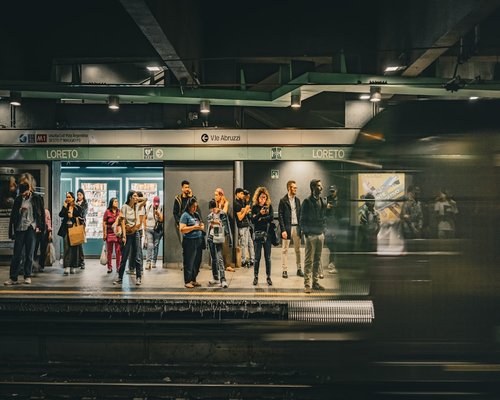 People commuting on a busy platform in Milan waiting for a regional train